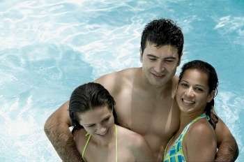 High angle view of two young women and a young man in a swimming pool