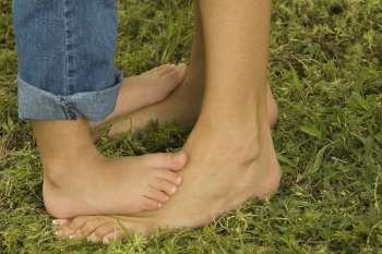 Low section view of a child feet on an adult´s feet