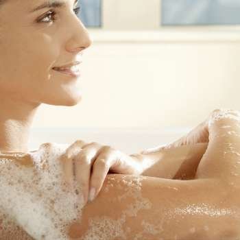 Side profile of a young woman smiling in a bathtub