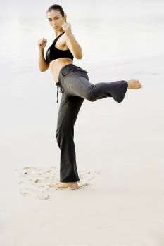 Portrait of a young woman practicing martial arts on the beach