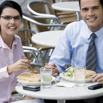 Portrait of a businessman and a businesswoman having lunch at a sidewalk cafe