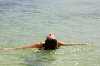 Rear view of a young woman swimming in the sea