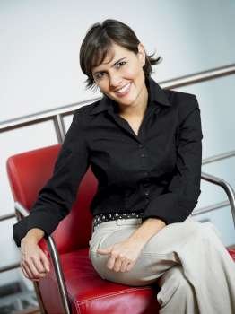 Portrait of a businesswoman smiling and sitting in an armchair