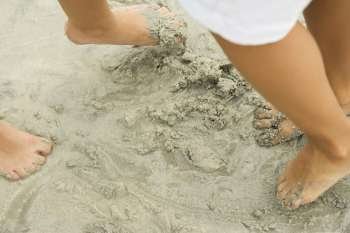 Low section view of two people´s feet in sand