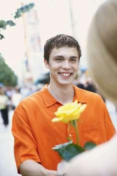 Close-up of a young man holding a flower