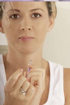 Portrait of a mid adult woman holding a nail clipper