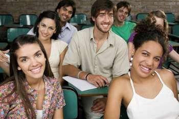 Portrait of university students sitting in a classroom and smiling