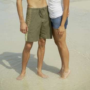 Young man and a teenage girl standing on the beach
