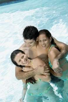 High angle view of two young women and a young man in a swimming pool