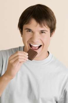 Portrait of a young man eating a biscuit
