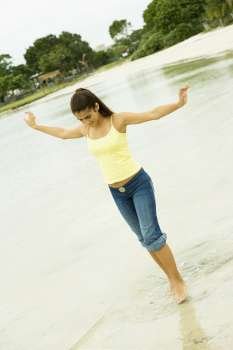 Girl standing in a lake with her arms outstretched
