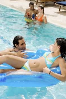 High angle view of two couples in a swimming pool