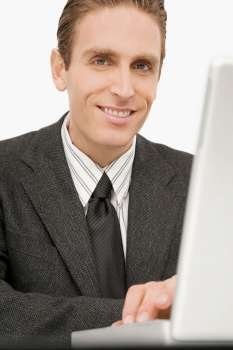 Portrait of a businessman working on a laptop and smiling