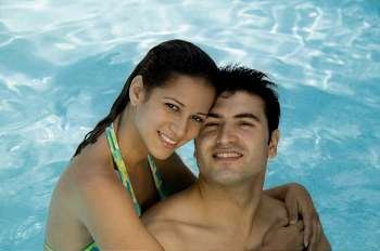 Portrait of a young couple smiling in a swimming pool