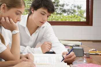 Close-up of a schoolgirl and a schoolboy studying together in a classroom