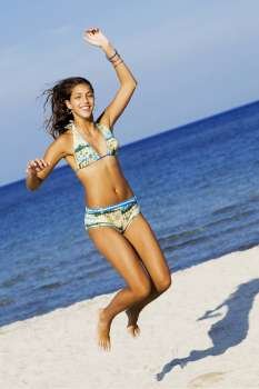 Teenage girl jumping on the beach