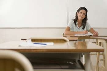 Portrait of a female teacher sitting in a classroom