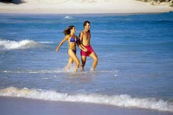 A couple running through the seawater, Horse-shoe Bay beach, Bermuda