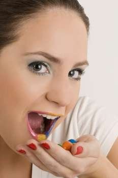 Portrait of a young woman eating candies