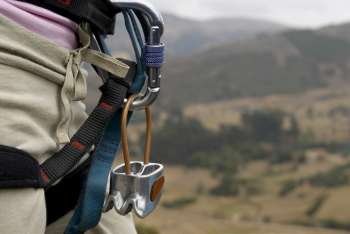 Mid section view of a rock climber carrying rock climbing equipments