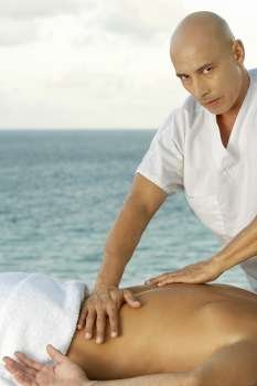 Portrait of a mature man giving a man a back massage