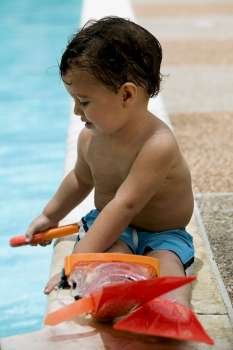 Close-up of a boy sitting by the pool
