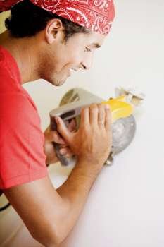 Side profile of a young man working with a circular saw