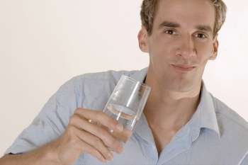 Portrait of a mid adult man holding a glass of water