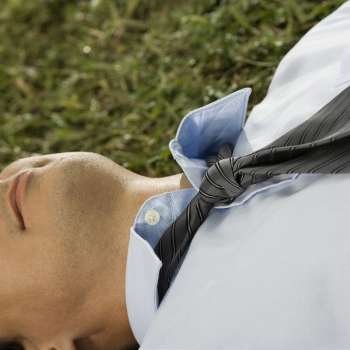 Close-up of a businessman lying on the grass
