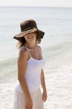 Close-up of a young woman standing on the beach and smiling