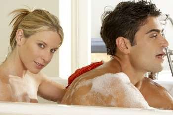 Portrait of a young woman scrubbing a young man´s back