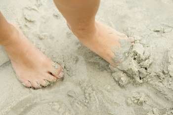 Low section view of a person´s foot in sand