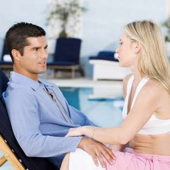 Side profile of a young woman and a mid adult man sitting on a deck chair