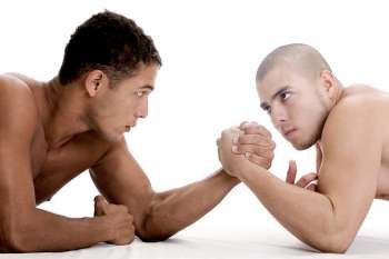 Side profile of two young men arm wrestling