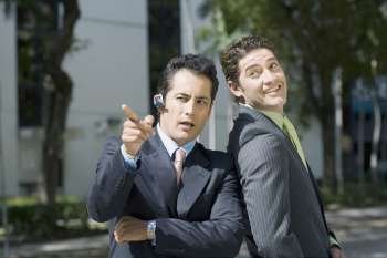 Businessman pointing forward with another businessman standing beside him