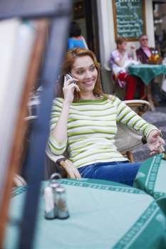 Young woman talking on a mobile phone in a restaurant 