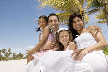 Mid adult couple with their two daughters on the beach