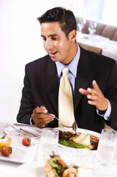 Close-up of a businessman sitting at a table and eating
