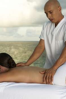Massage therapist massaging a woman´s back