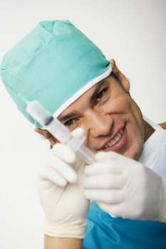 Portrait of a male surgeon holding a syringe