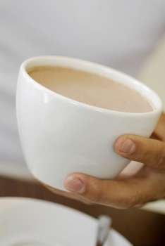 Close-up of a person´s hand holding a cup of coffee