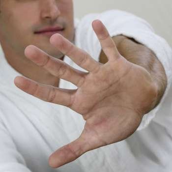 Close-up of a young man showing a stop gesture