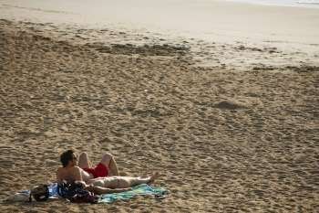 High angle view of a couple lying on the beach, Grande Plage, Biarritz, France