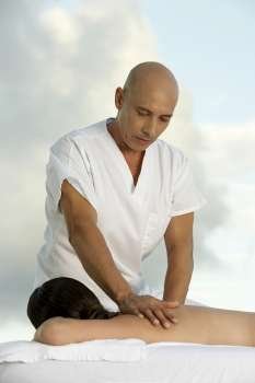 Young woman getting a back massage from a mature man