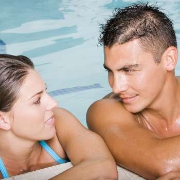 Close-up of a young couple looking at each other at the poolside