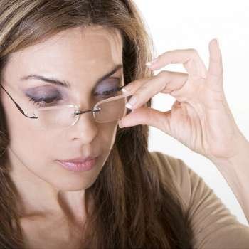 Close-up of a mid adult woman adjusting her eyeglasses