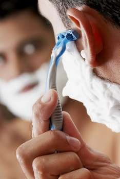 Close-up of a young man shaving