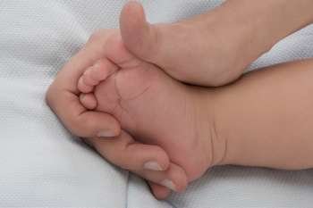 Close-up of a woman´s hand holding a baby´s foot