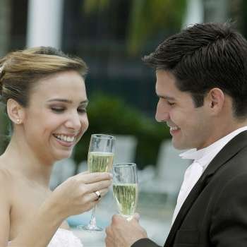Side profile of a bride and her groom toasting with champagne flutes