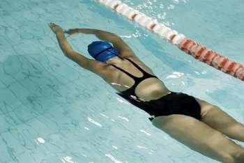 Rear view of a teenage girl swimming in a swimming pool